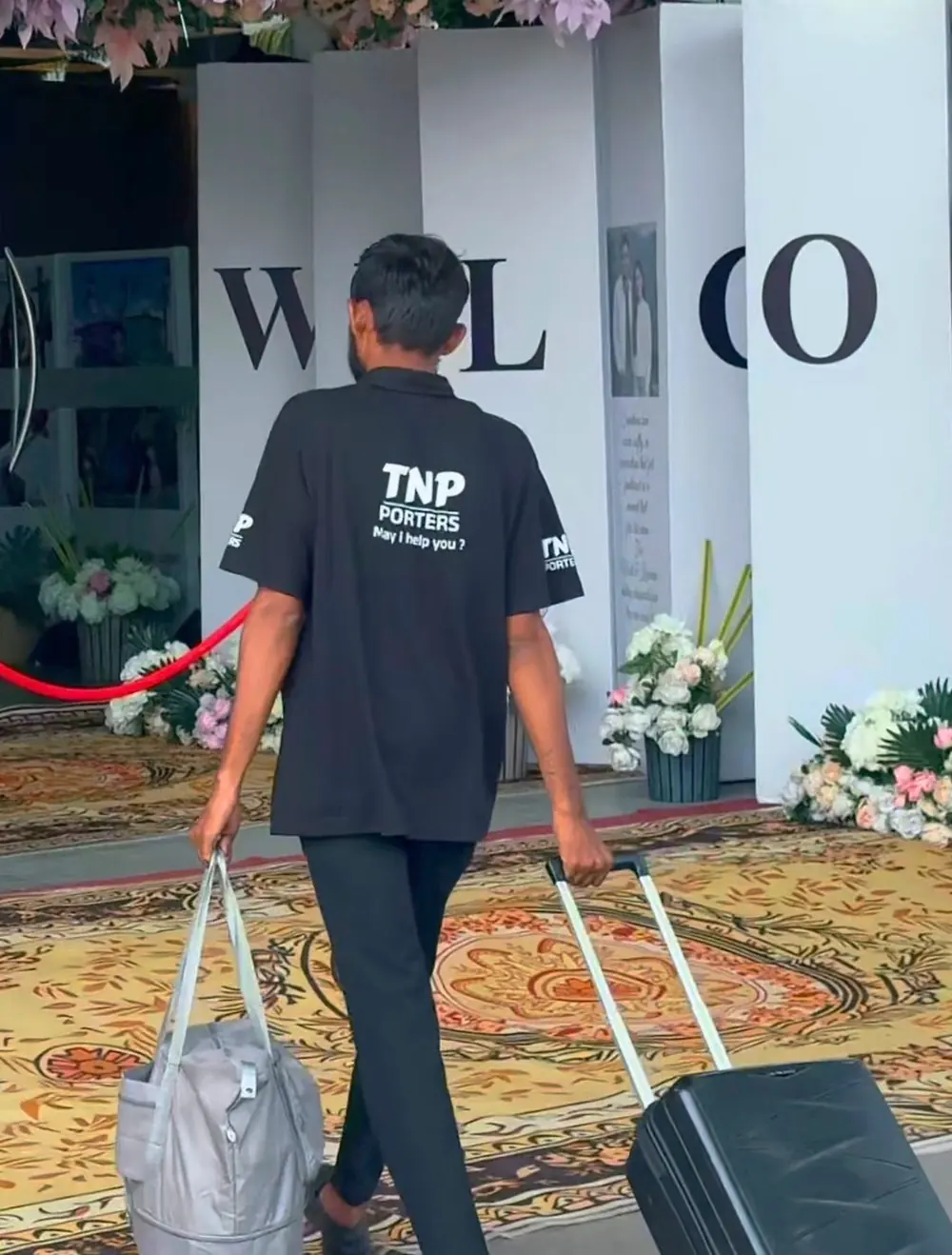 A TNP porter carrying luggage into a venue